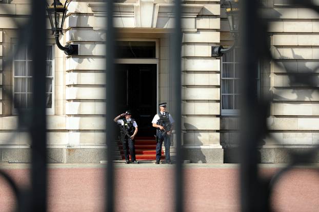 Police officers are seen on duty within the grounds of Buckingham Palace in London