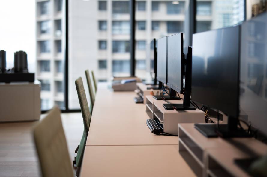 A,Row,Of,Empty,Desks,With,Computer,Monitors,And,Chairs