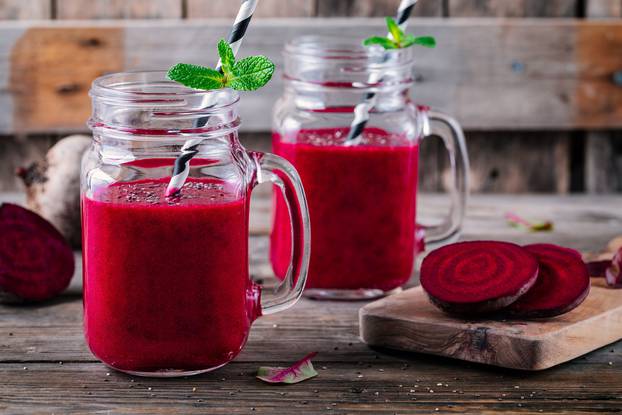 healthy detox beet smoothie with chia seeds in a mason jar on a wooden background