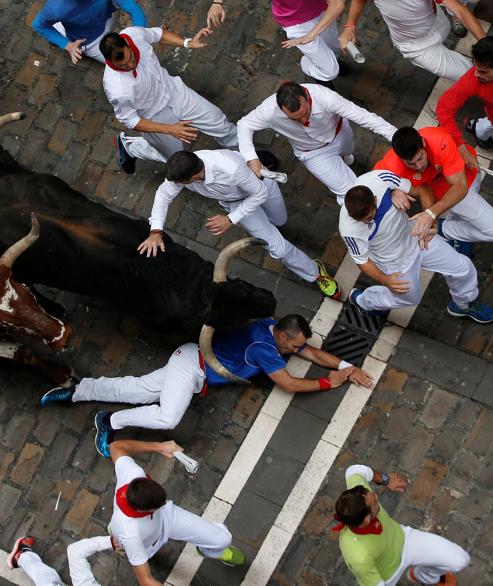 Runners sprint ahead of bulls during the fourth running of the bulls at the San Fermin festival in Pamplona