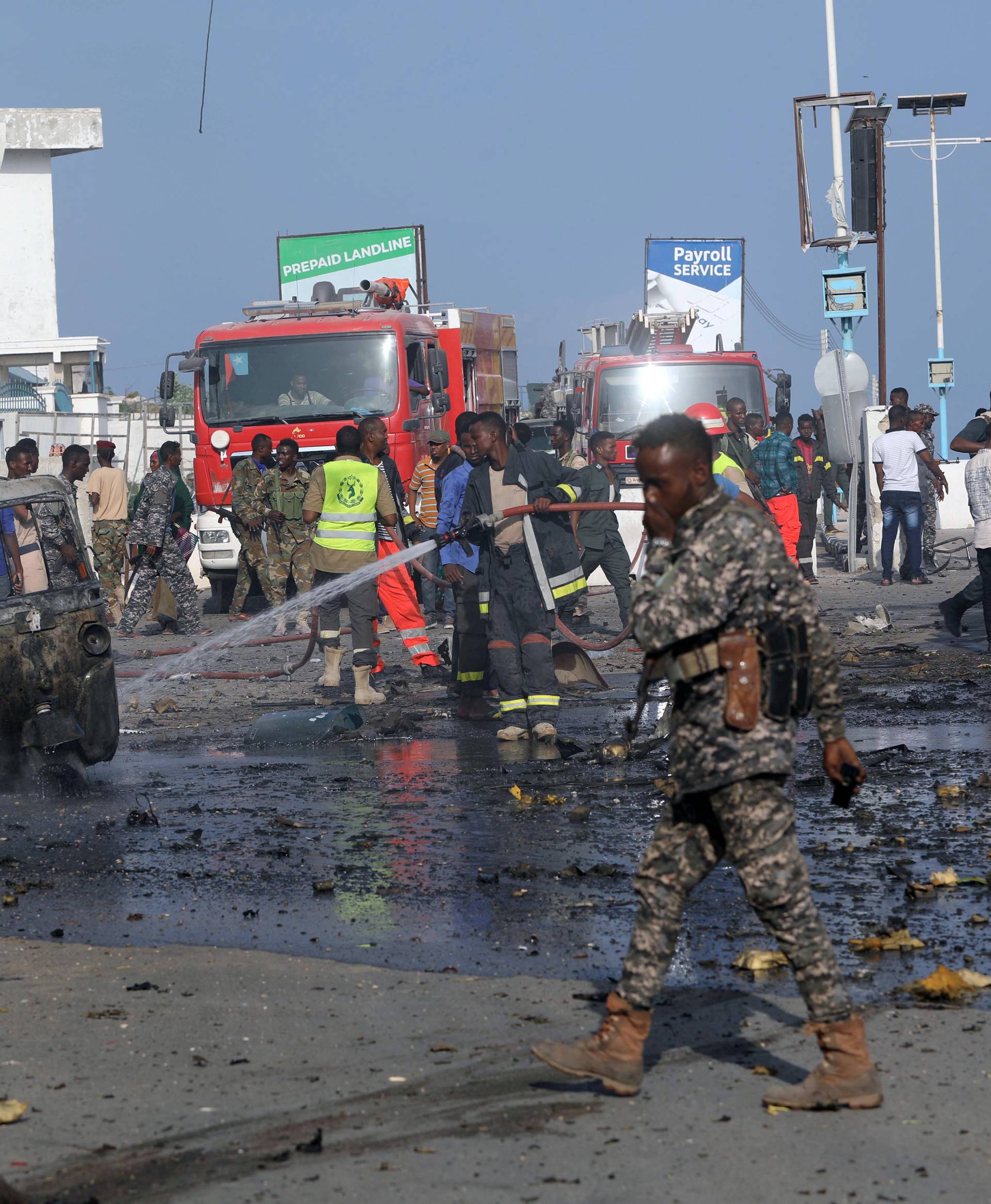 Somali security officers clear the scene of an explosion at a checkpoint near Somalia's parliament and interior ministry in Mogadishu