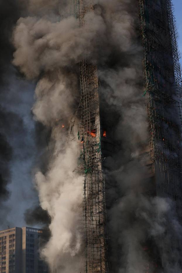 Flames engulf bamboo scaffolding across multiple buildings at Wang Fuk Court housing estate, in Tai Po