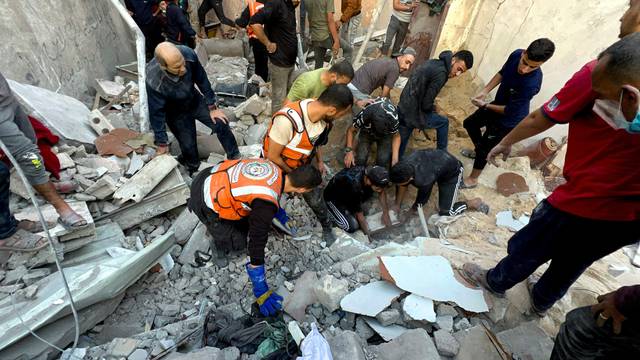 Palestinians search for casualties at the site of Israeli strikes on houses in Jabalia refugee camp at the Indonesian hospital, in the northern Gaza Strip