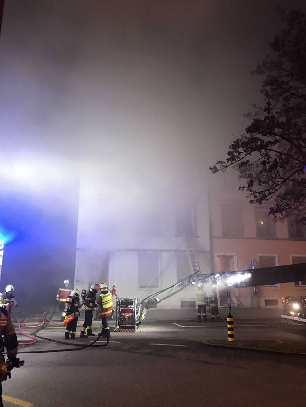 Firefighters are seen in front of a house where six people were killed in an apartment fire early on Monday morning, police said,in Solothurn