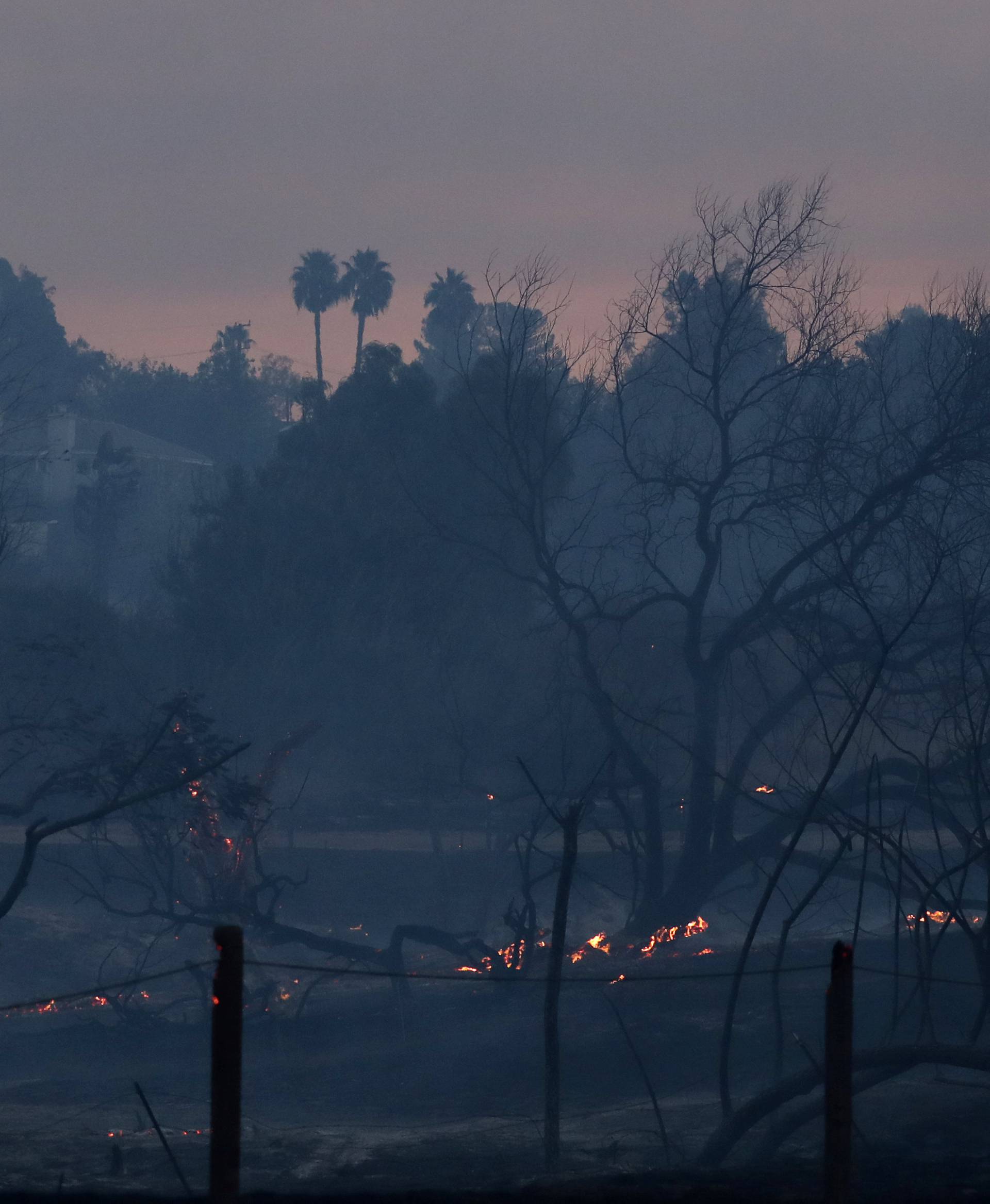 A local community park is left burnt and smoldering after a wind driven wildfire moved through Orange, California