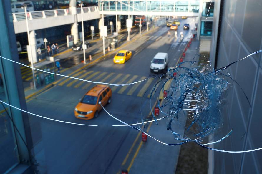 Vehicles are seen behind a broken window at Turkey's largest airport