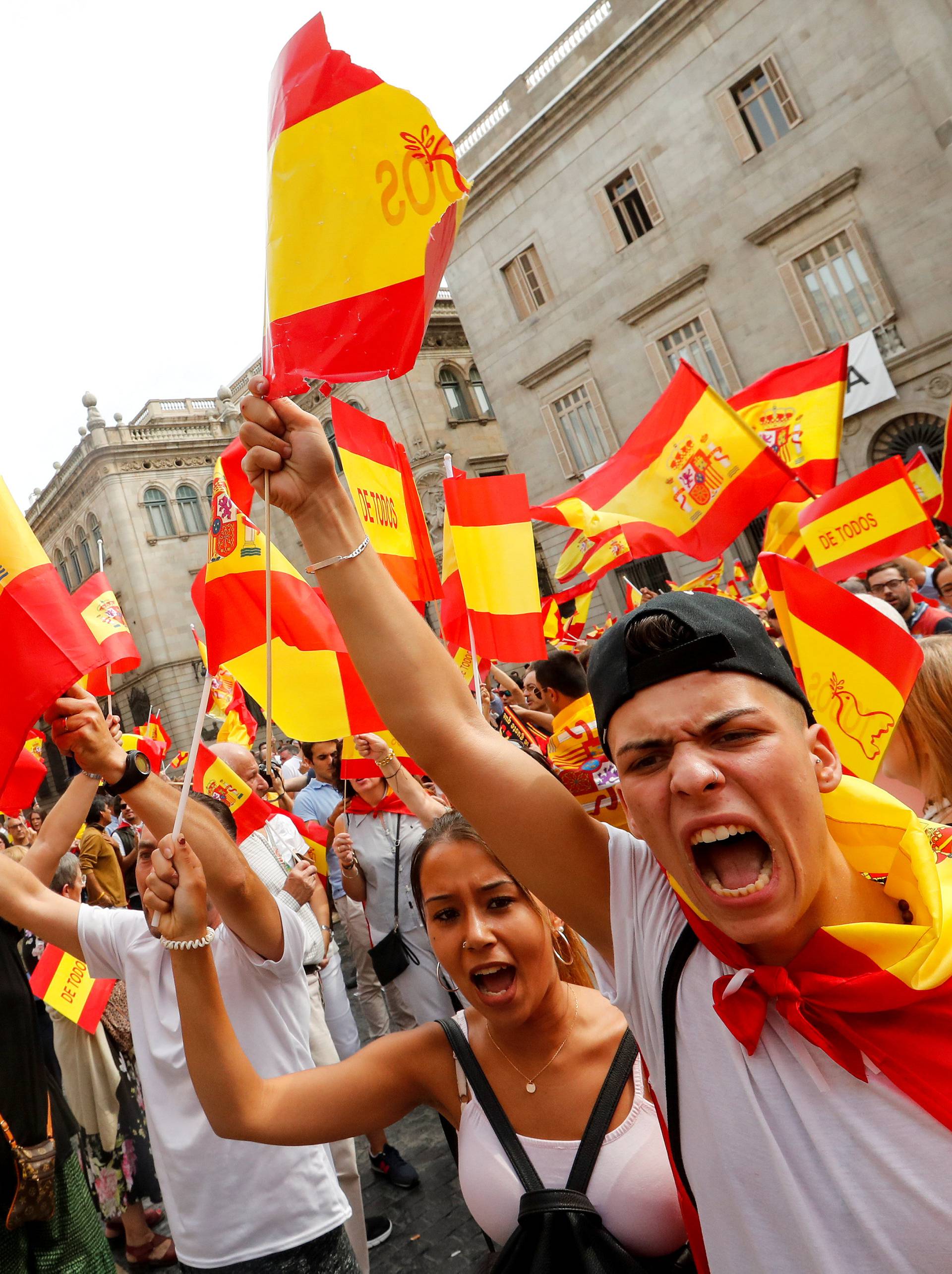 People shout and hold up Spanish flags during a demonstration in favor of a unified Spain a day before the banned October 1 independence referendum, in Barcelona