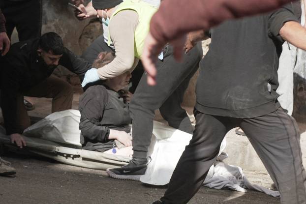 Paramedics and civilians help an injured woman following an Israeli air strike in Beirut