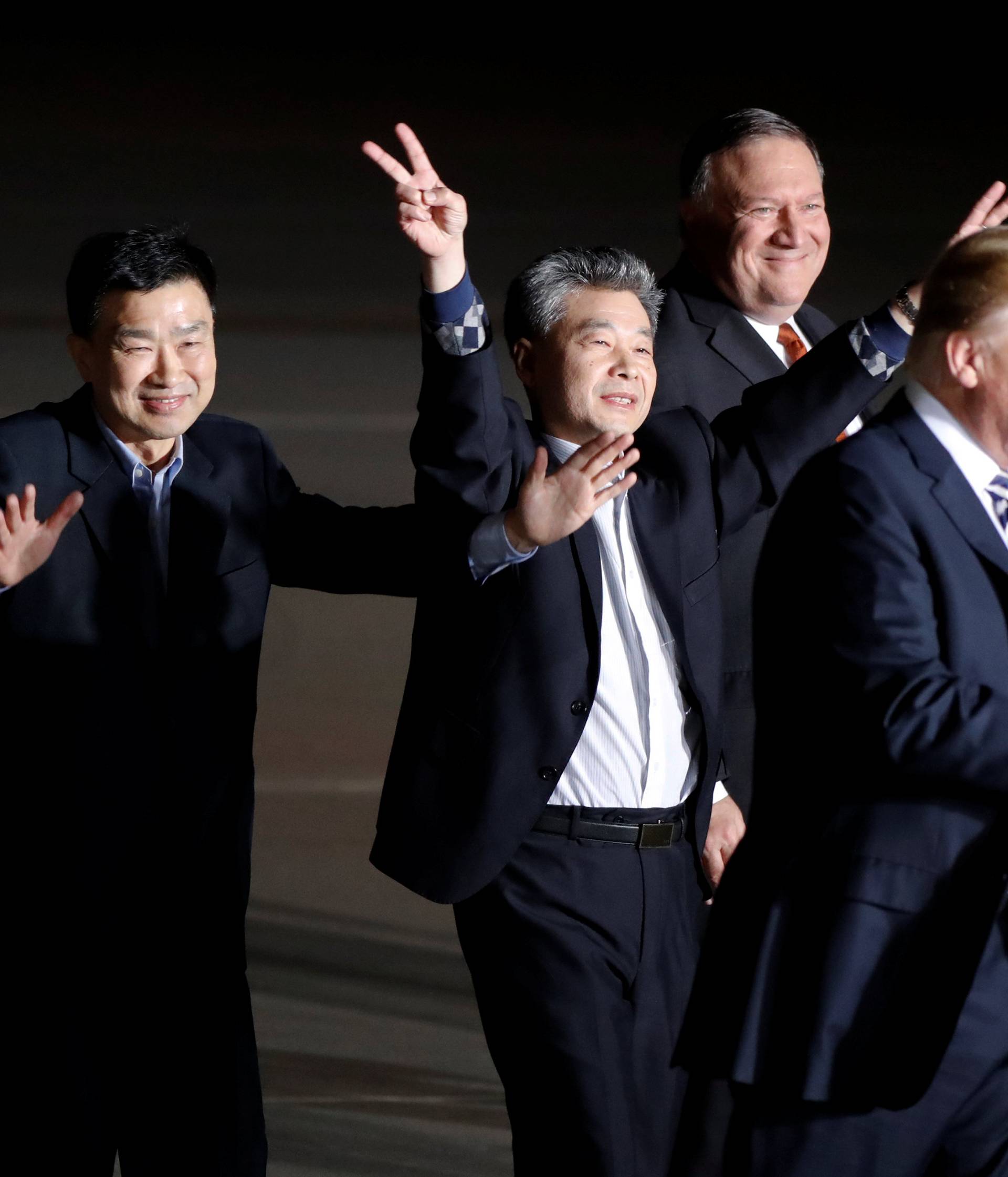The three Americans formerly held hostage in North Korea gesture next to U.S.President Donald Trump and Secretary of State Mike Pompeo, upon their arrival at Joint Base Andrews