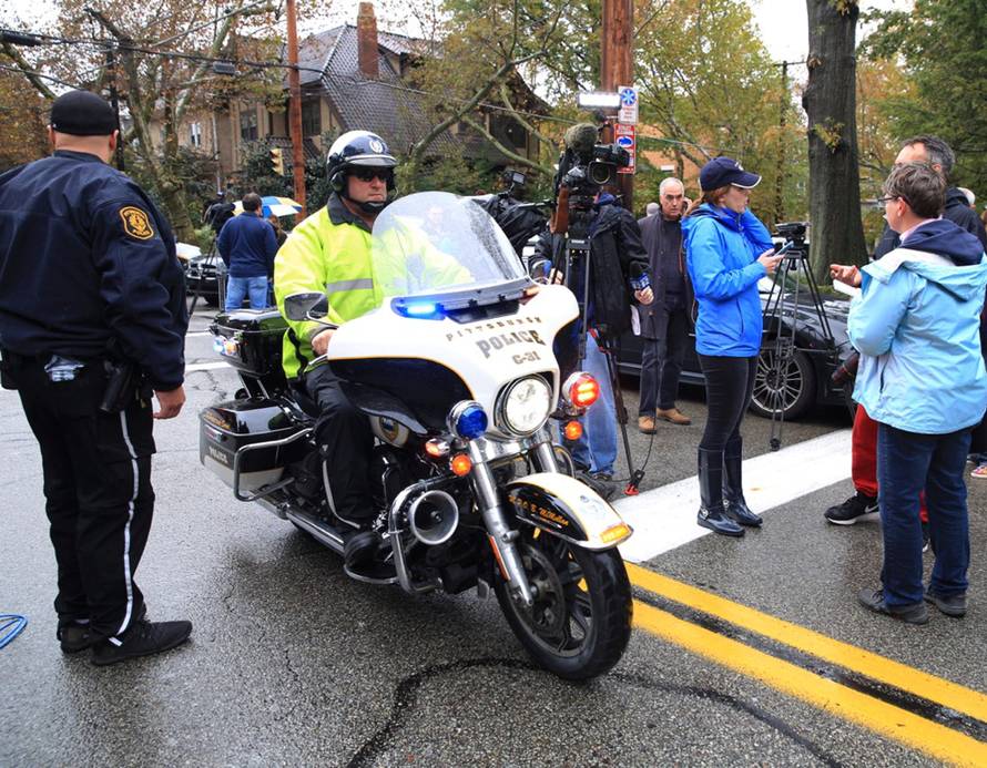 A police officer on motorcycle passes through a roadblock as he responds after a gunman opened fire at the Tree of Life synagogue in Pittsburgh