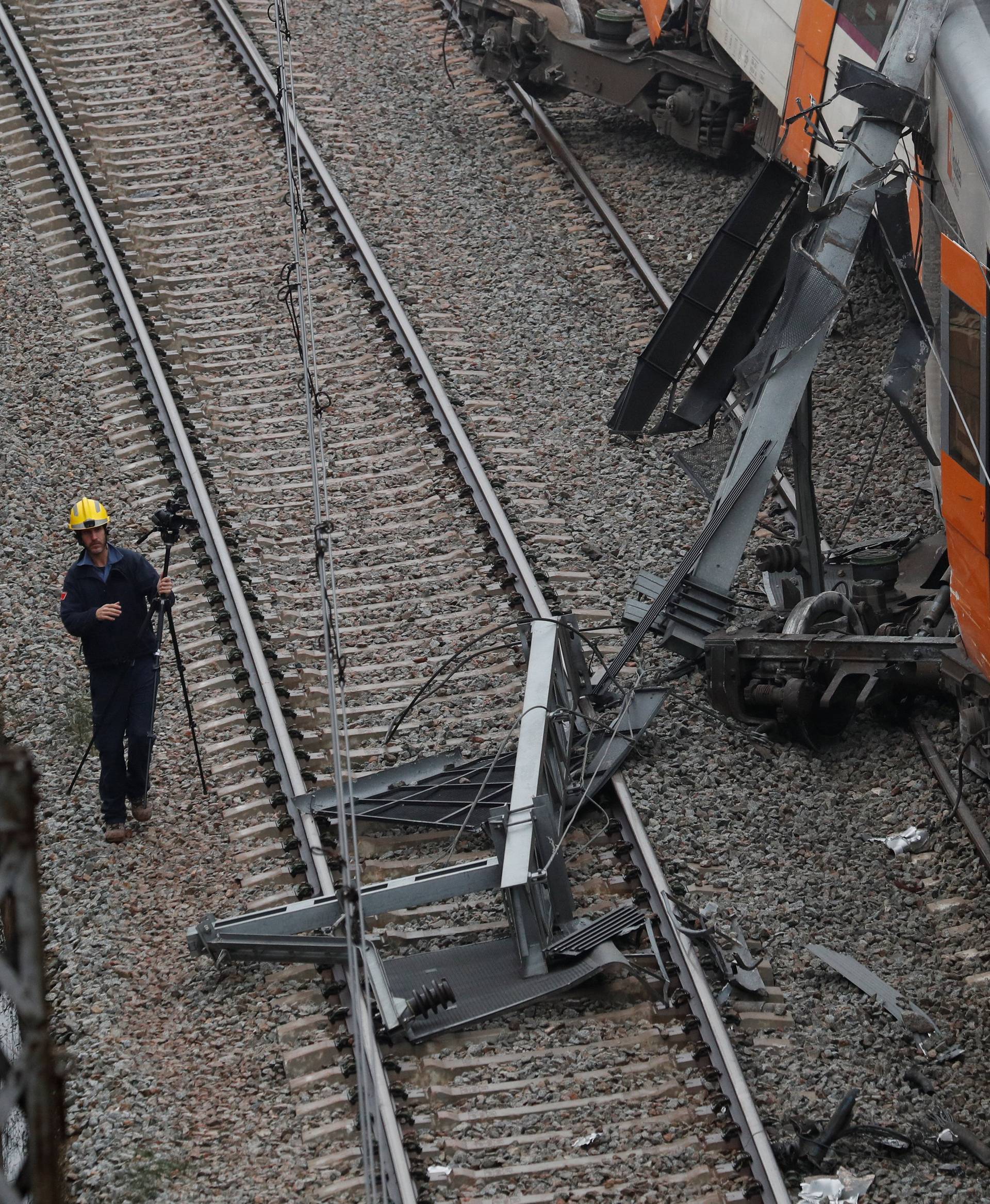 A worker investigates the scene after a commuter train derailed between Terrassa and Manresa outside Barcelona