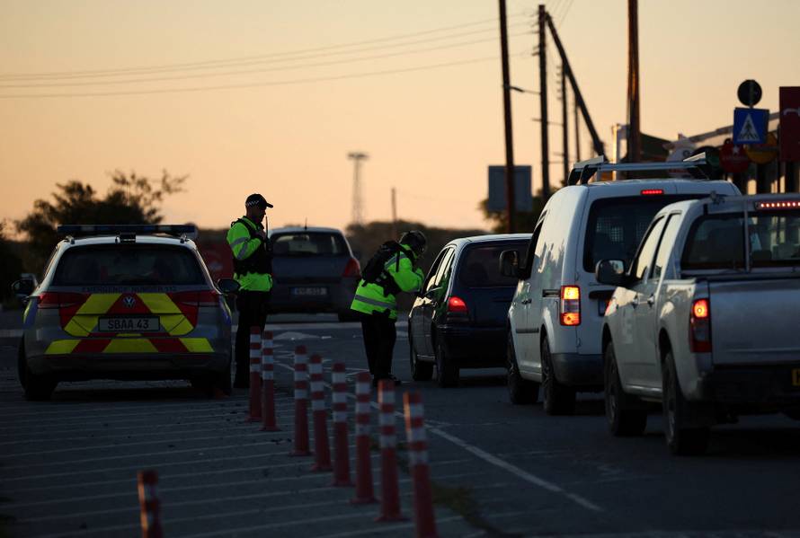 Police check vehicles on the road leading to RAF Akrotiri, a British sovereign base in Cyprus, which was hit by an unmanned drone overnight, causing limited damage