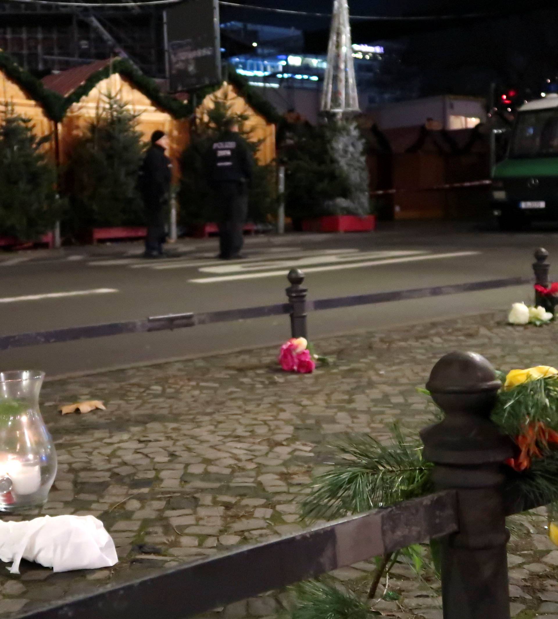 A candle and flowers are seen near the site where a truck ploughed through a crowd at a Berlin Christmas market