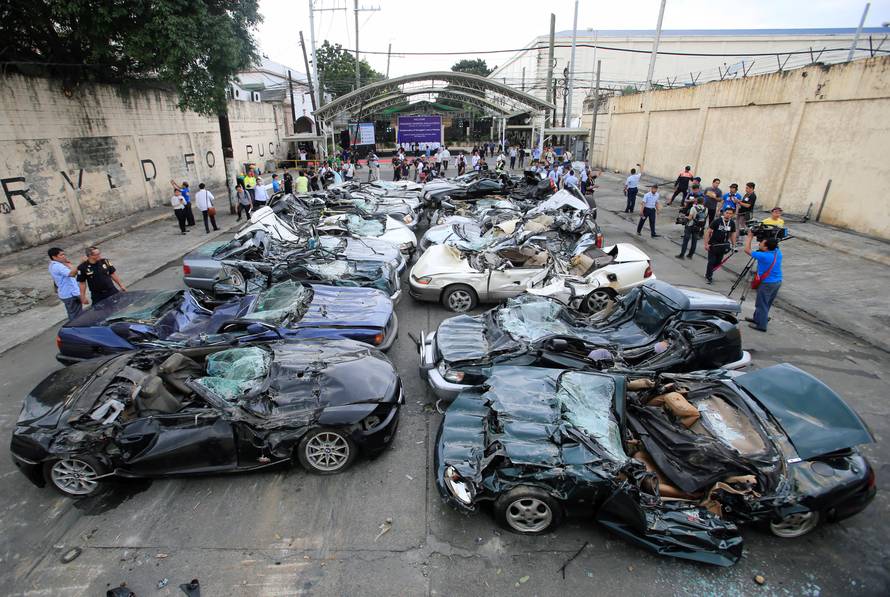 A bulldozer destroys condemned smuggled luxury cars worth 61,626,000.00 pesos during the 116th Bureau of Customs founding anniversary in Manila