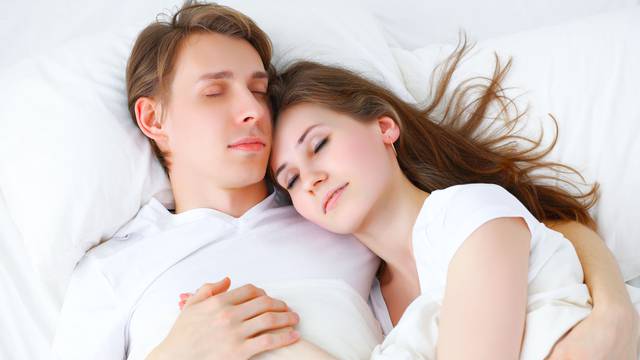 Happy couple  sleeping in bed at home