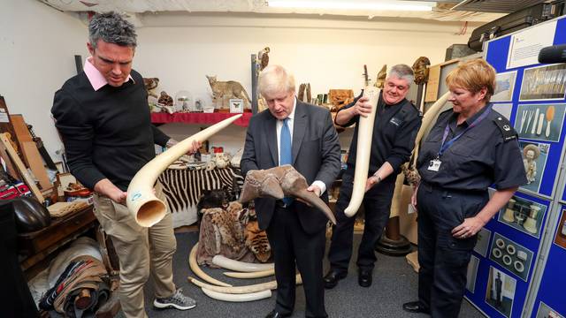 Former England cricketer Kevin Pietersen and Britain's Foreign Secretary Boris Johnson visit the ÃDead ShedÃ at Heathrow Airport, to observe items relating to the illegal wildlife trade, in west London