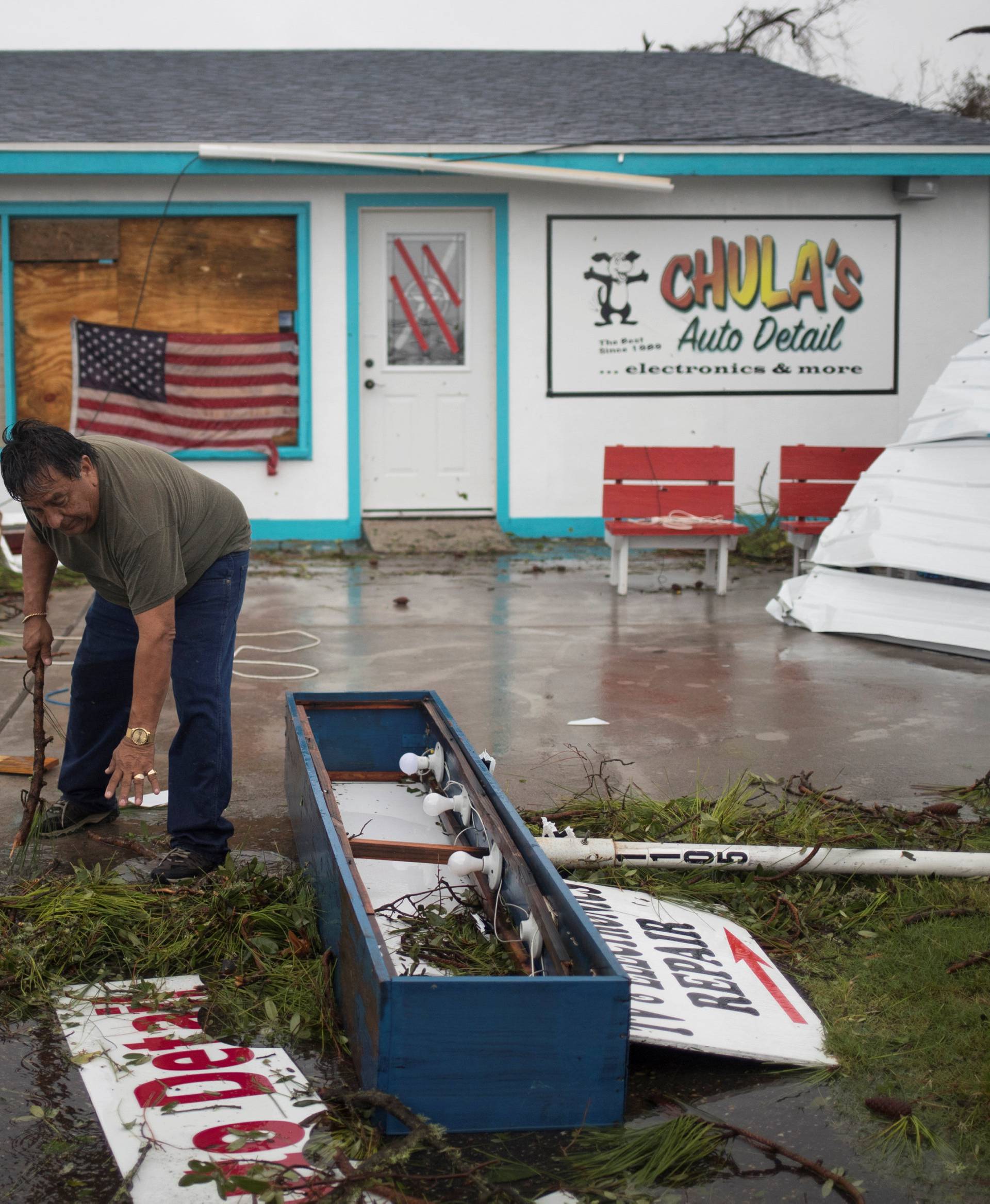 Business owner and resident clears debris from outside his shop which was hit by Hurricane Harvey in Rockport, Texas