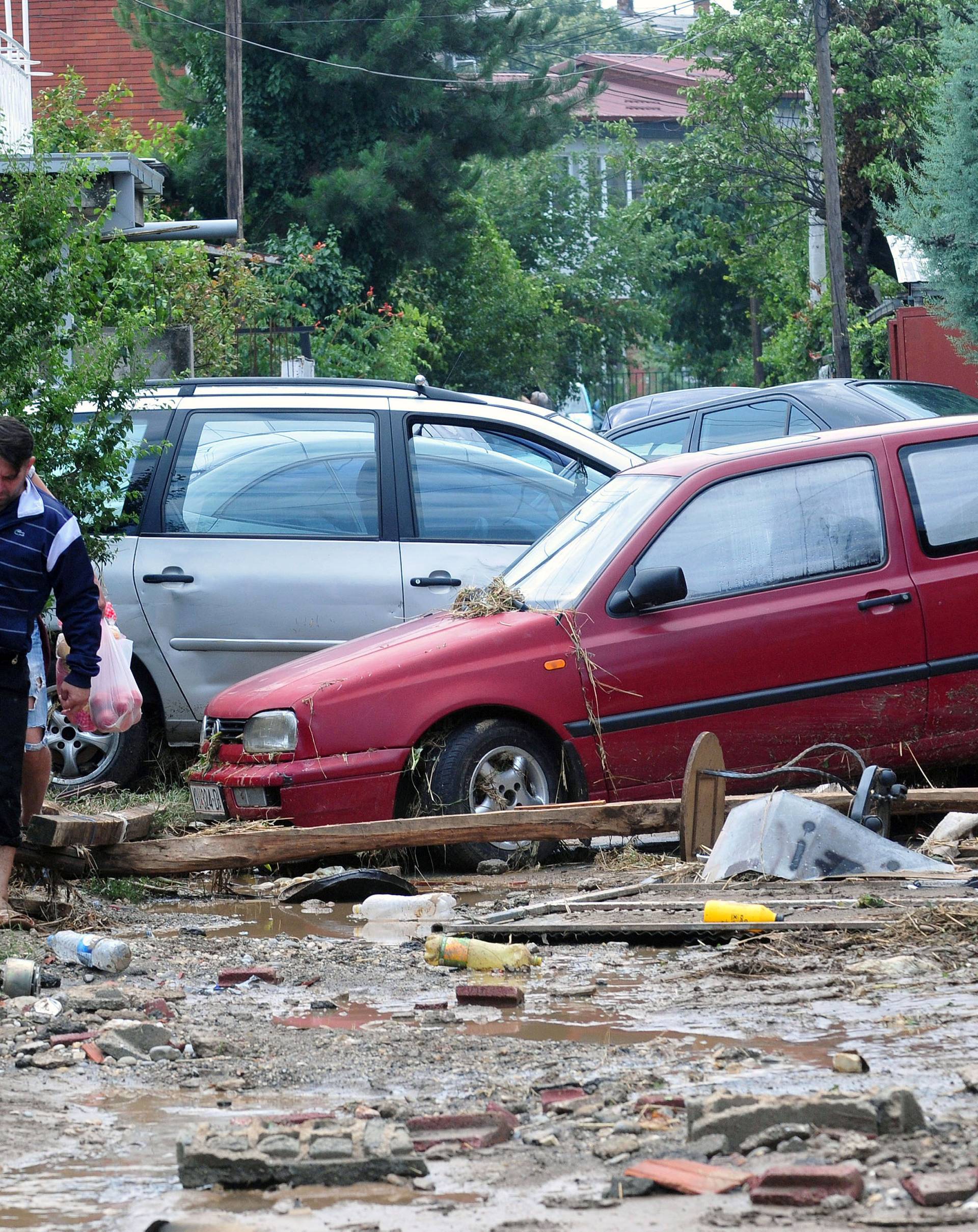 People walk on the street after heavy floods in Cento near Skopje