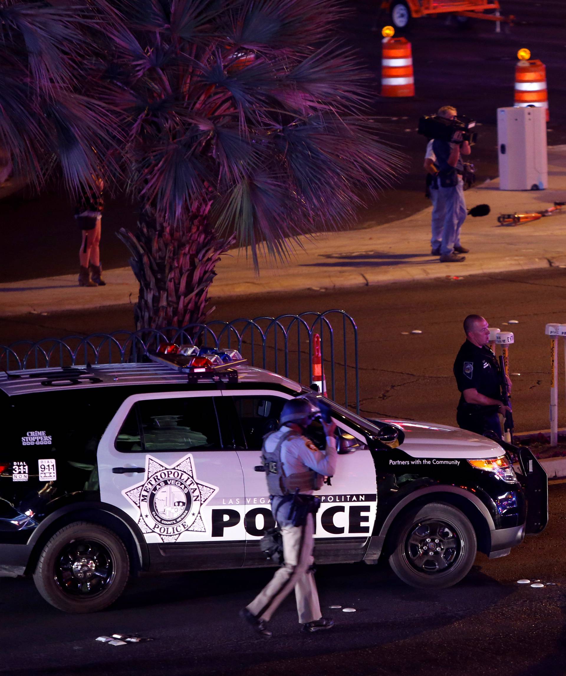 Las Vegas Metro Police officers gather near the intersection of Tropicana Avenue and Las Vegas Boulevard South after a mass shooting at a music festival on the Las Vegas Strip in Las Vegas