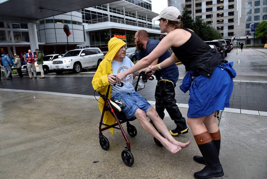 Aid workers push evacuee Frank Andrews into the George R. Brown Convention Center after Hurricane Harvey inundated the Texas Gulf coast with rain causing widespread flooding