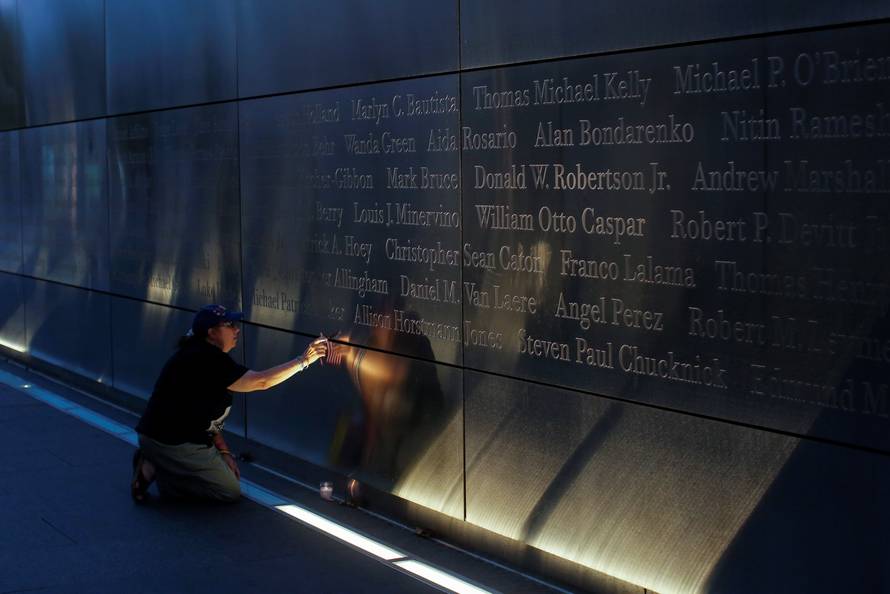 A mourner places a flag in the Empty Sky memorial on the morning of the 15th anniversary of the 9/11 attacks in New Jersey