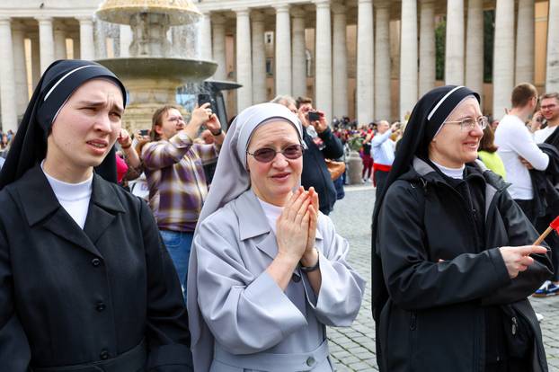 People watch Pope Francis makes first public appearance in five weeks, on a big screen in St. Peter's Square at the Vatican