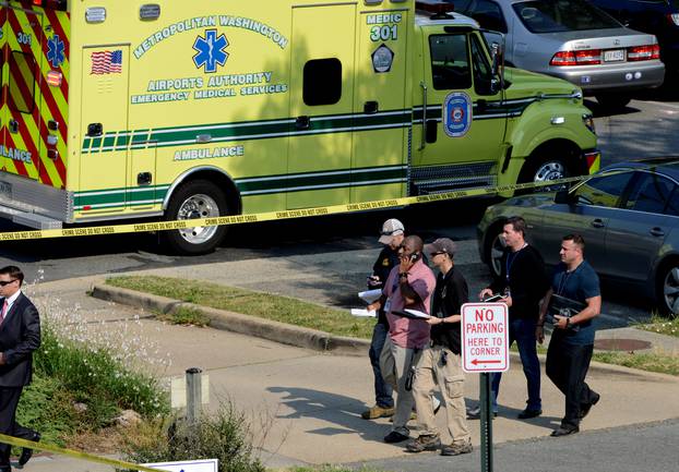 Police and investigators walk at the scene where shots were fired during a congressional baseball practice in Alexandria