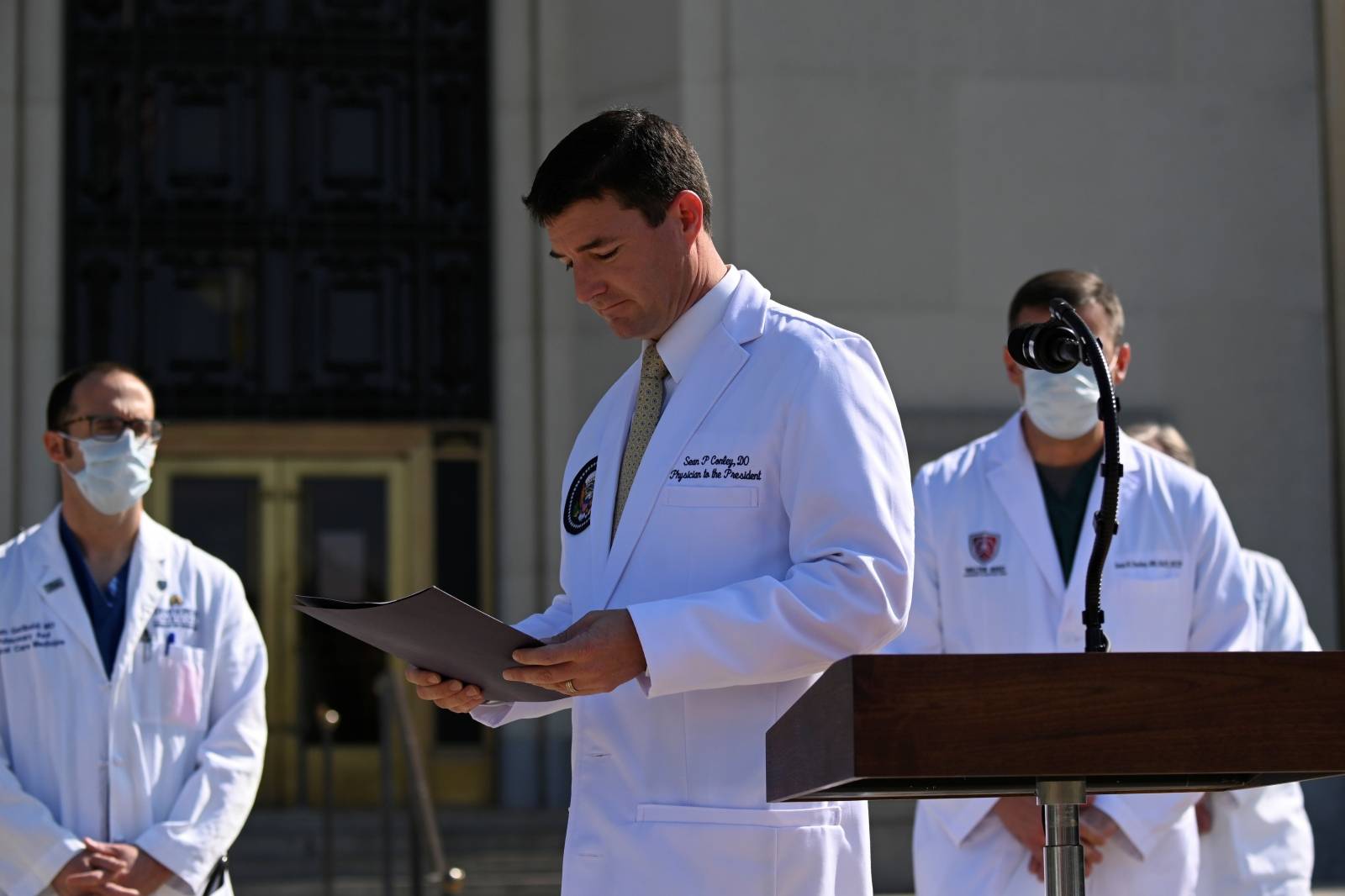 U.S. Navy Commander Dr. Sean Conley, the White House physician, looks at a folder during a briefing about U.S. President Donald Trump's health, in Bethesda