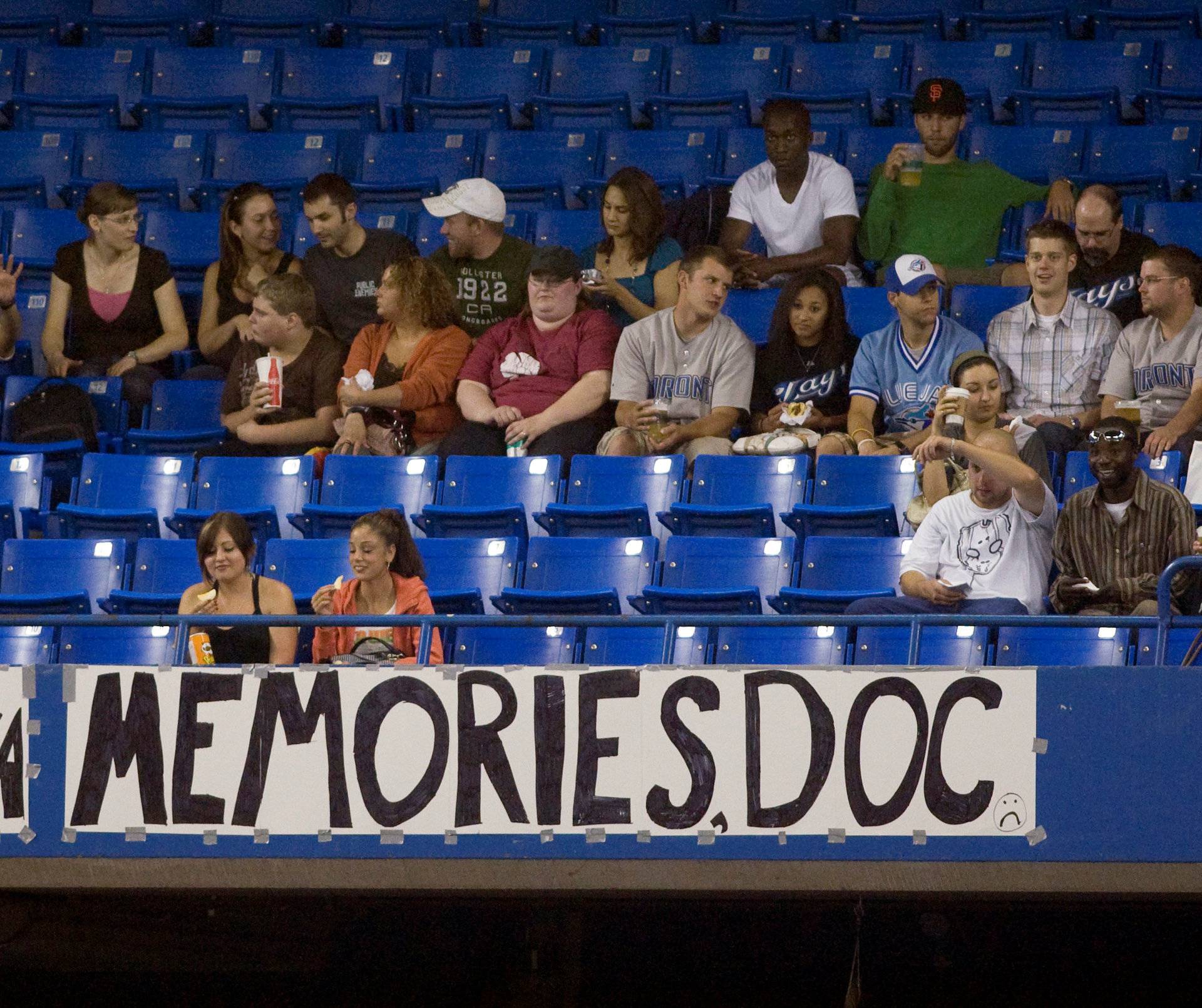 FILE PHOTO: Fans sit behind a sign as Blue Jays pitcher Halladay starts against the Rays before their MLB American League baseball game in Toronto