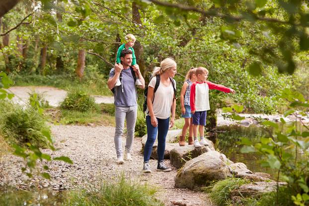 Family,Hiking,Along,Path,By,River,In,Uk,Lake,District