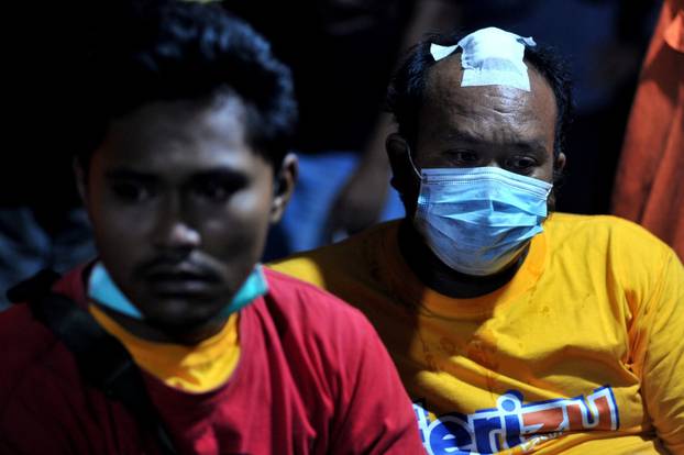 Passengers of sunken ferry KMP Yunice, rest as they arrive at Gilimanuk port in Bali