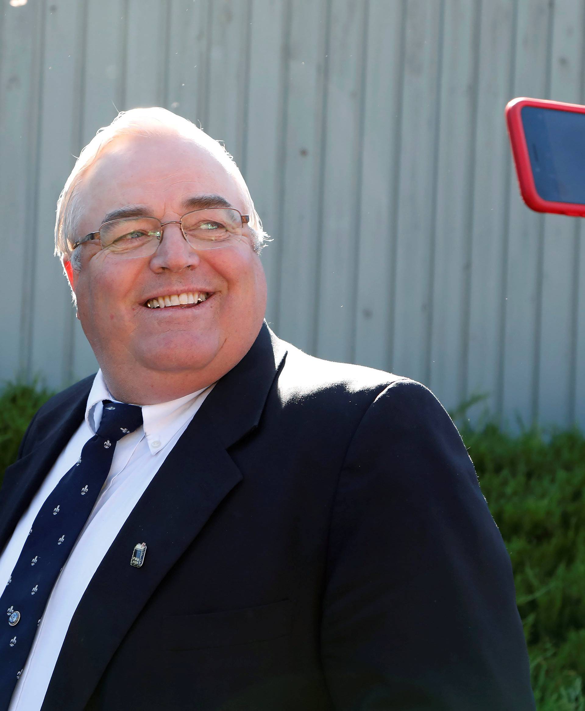 Winston Blackmore, who is accused of having two dozen wives, smiles at a reporter's phone as he arrives at the BC Supreme Court in Cranbrook, British Columbia, Canada