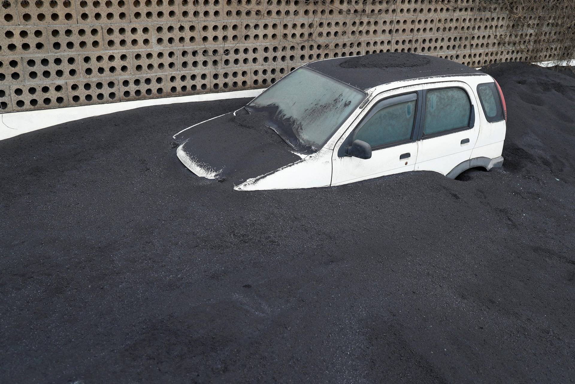 A car buried in the ash from the Cumbre Vieja volcano is seen in Las Manchas