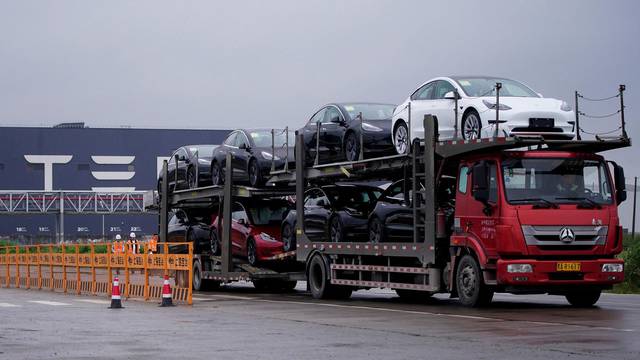 FILE PHOTO: A truck transports new Tesla cars at its factory in Shanghai