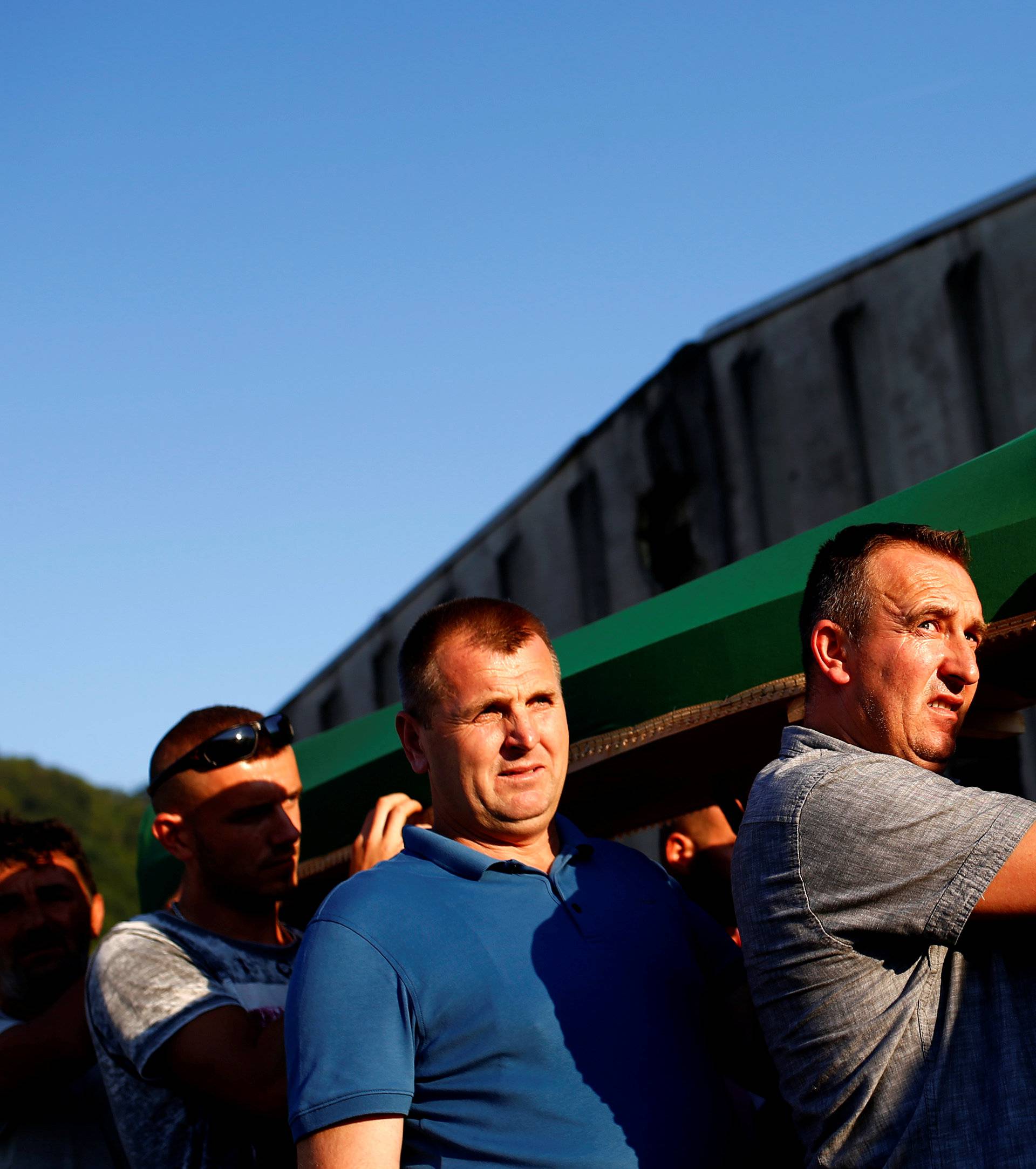 Muslim men carry coffins of their relatives, who are newly identified victims of the 1995 Srebrenica massacre, before a joint burial in Potocari near Srebrenica