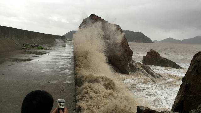 A man records waves whipping the shore before Typhoon Meranti makes a landfall on southeastern China, in Wenling