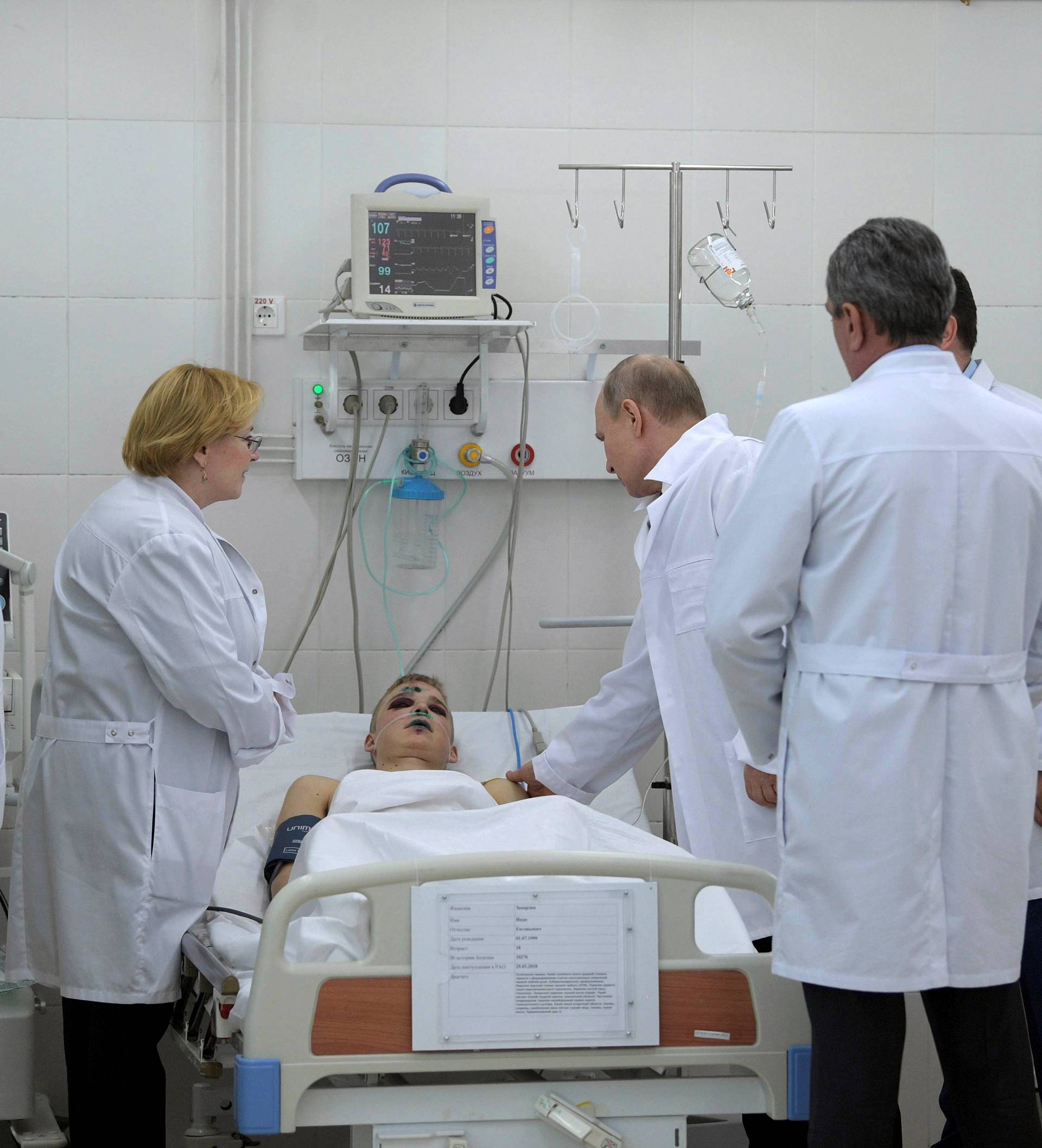 Russian President Vladimir Putin meets with victims injured during a fire in a shopping mall, at a hospital in Kemerovo