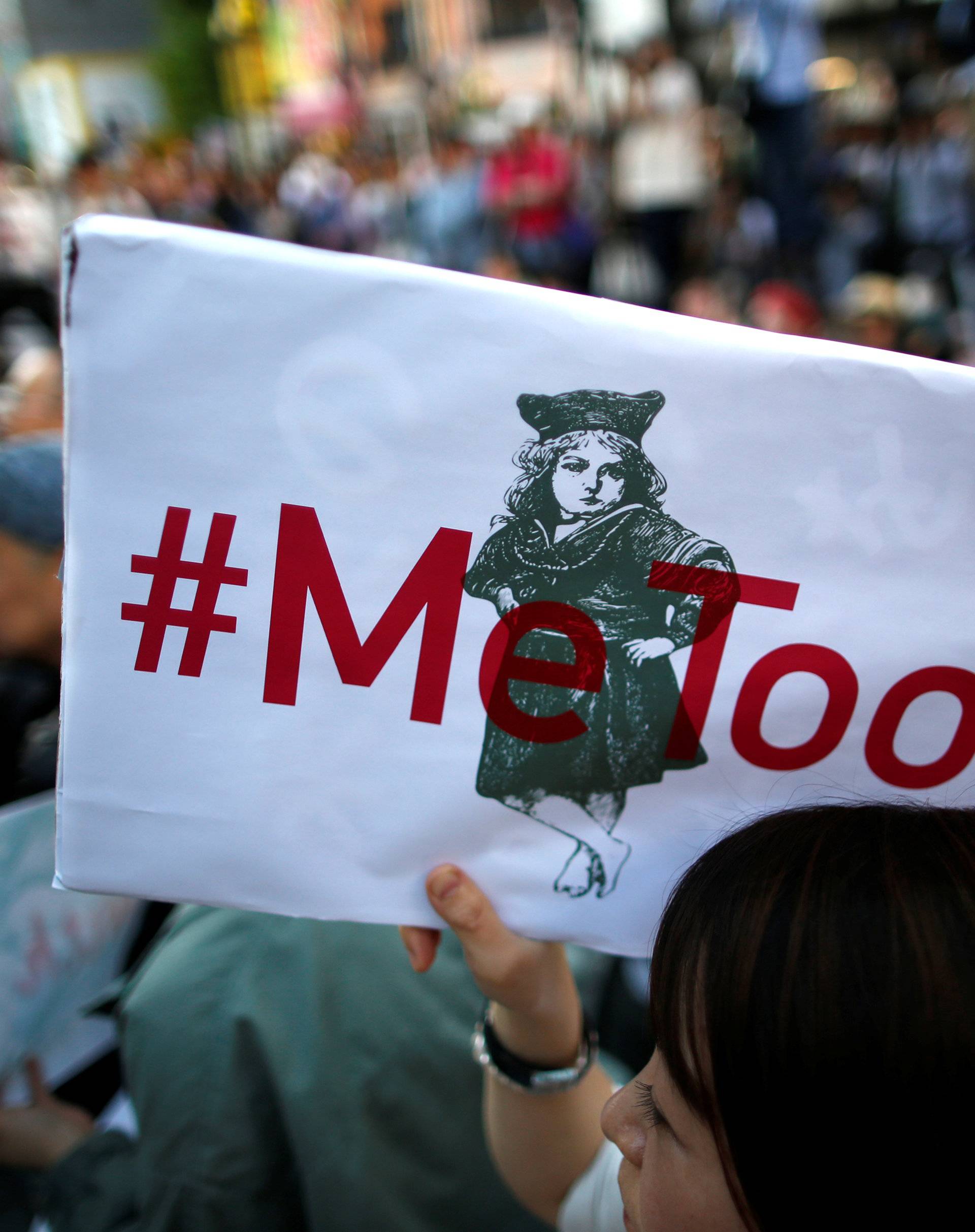 A protester raises a placard reading "#MeToo" during a rally against harassment in Tokyo