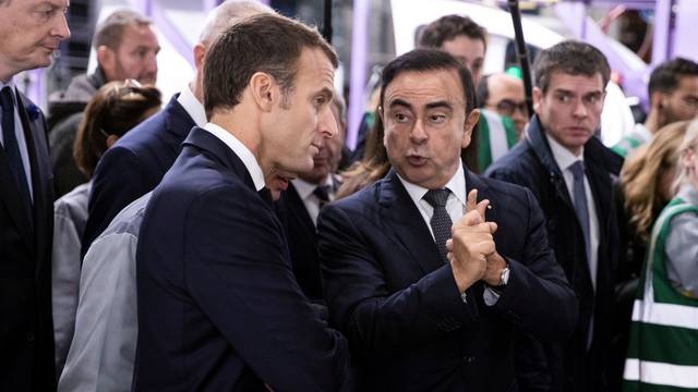 French President Emmanuel Macron discusses with Renault CEO Carlos Ghosn during a visit in the Renault factory in Maubeuge