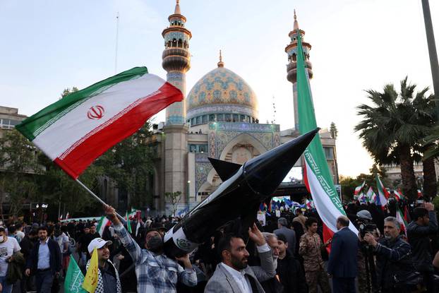 FILE PHOTO: Iranians carry a model of a missile during a celebration following the IRGC attack on Israel, in Tehran