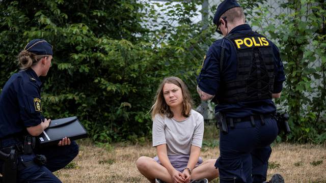 FILE PHOTO: Police talk to Greta Thunberg as they move climate activists who are blocking the entrance to Oljehamnen in Malmo