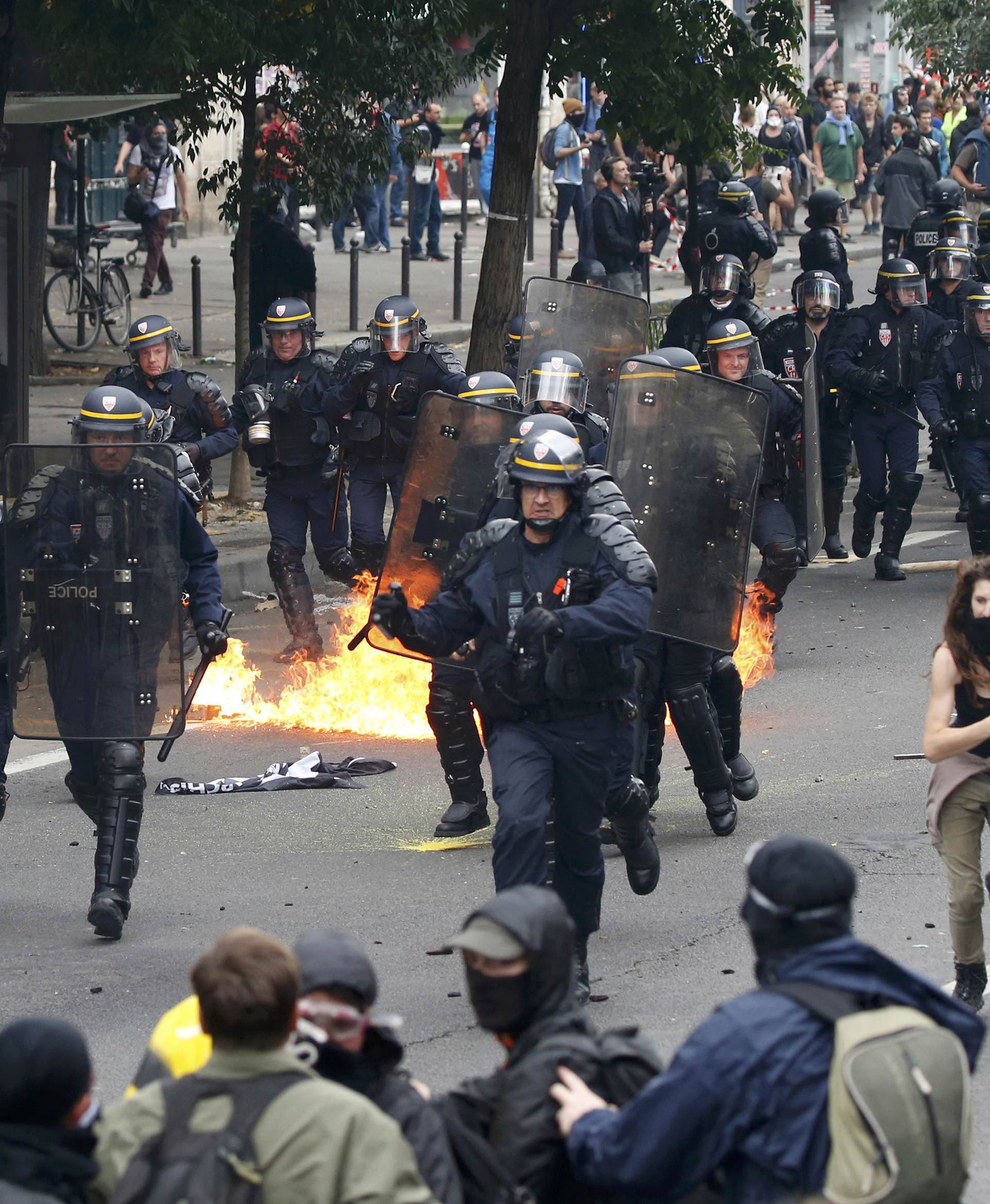 Demonstrators clash with French riot police during a march in Paris