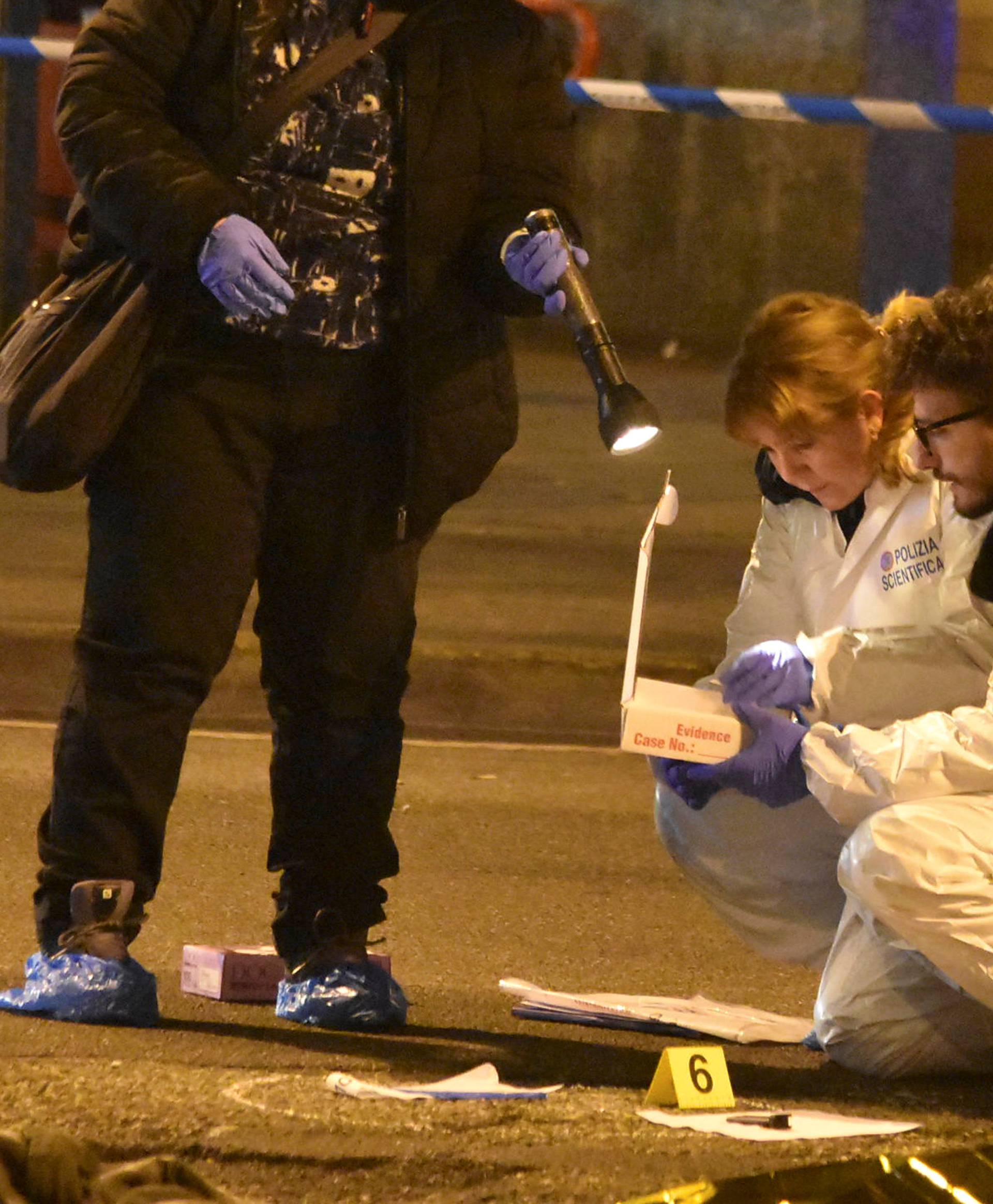 Italian Police officers work next to the body of Anis Amri, the suspect in the Berlin Christmas market truck attack, in a suburb of the northern Italian city of Milan