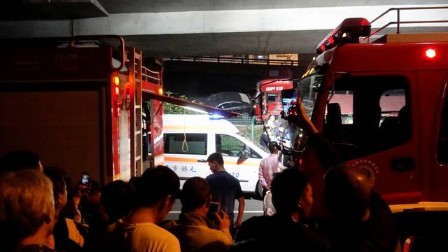 Rescue vehicles and ambulance are seen at the site after a part of highway overpass collapsed in Wuxi, Jiangsu