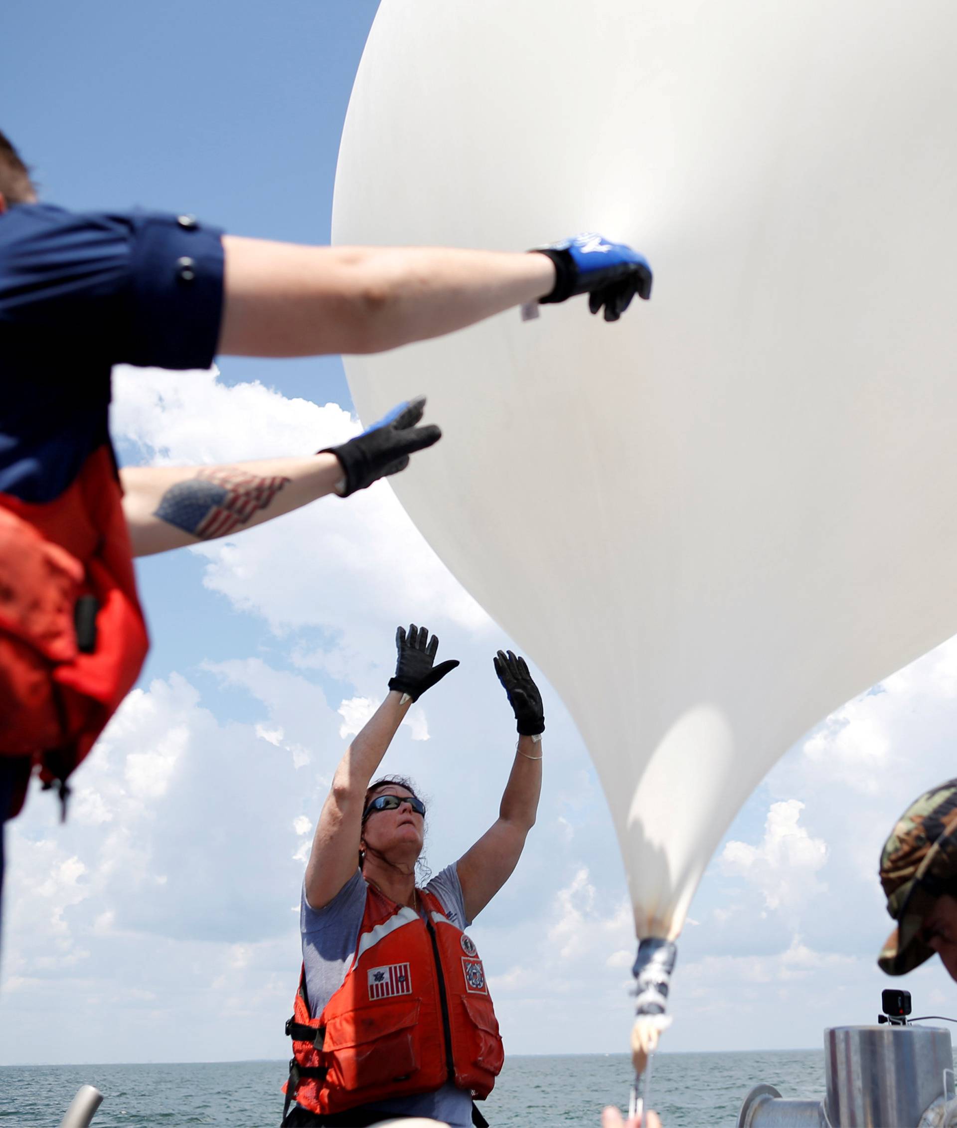 College of Charleston professor Dr. Cassandra Runyon releases a balloon during a test launch for the Space Grant Ballooning Project in preparations for Monday's solar eclipse on board a US Coast Guard response boat at sea near Charleston