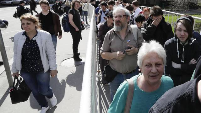 People stand in a queue to get to an office of the presidential administration during an opposition protest in Moscow
