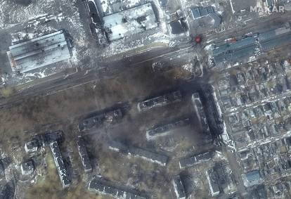A satellite image shows a multispectral close up view of apartment buildings and fires, in the western section of Mariupol