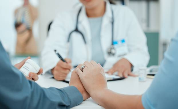Hospital,,Holding,Hands,And,Doctor,With,Couple,For,Consulting,,Wellness