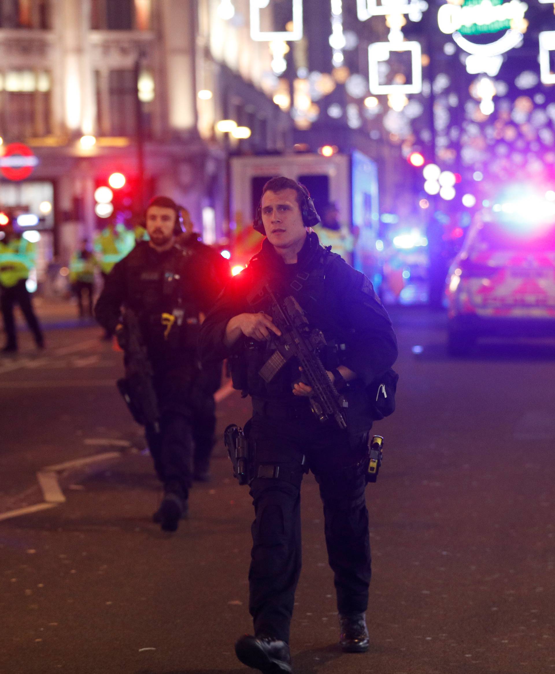 Armed police officers walk along Oxford Street, in London