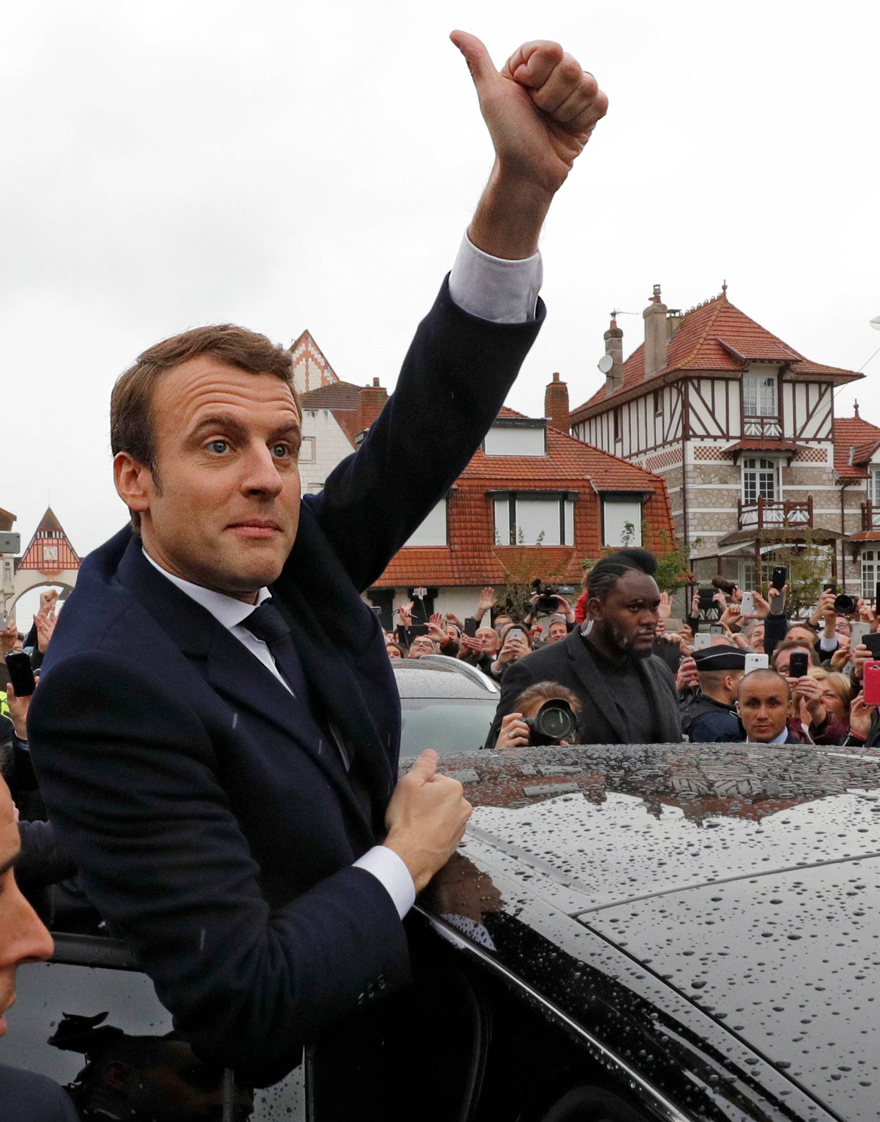 French presidential election candidate Emmanuel Macron gives thumb up to supporters as he leaves a polling station after voting in the second round of 2017 French presidential election, in Le Touquet